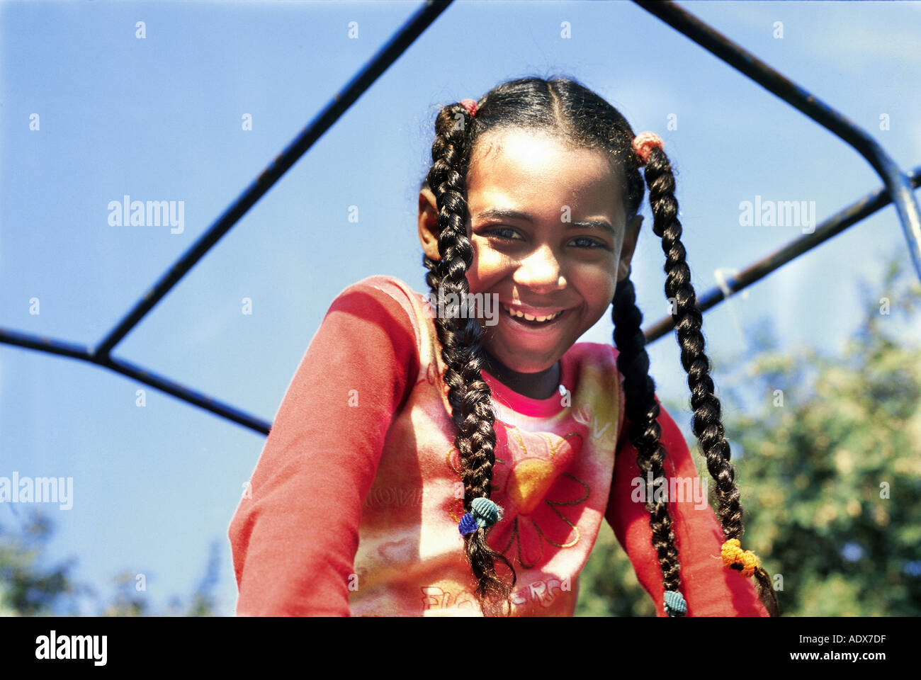 Children girl iron bars climbing frame smile smiling braid braids braided hair happy fun happiness expression emotion people per Stock Photo