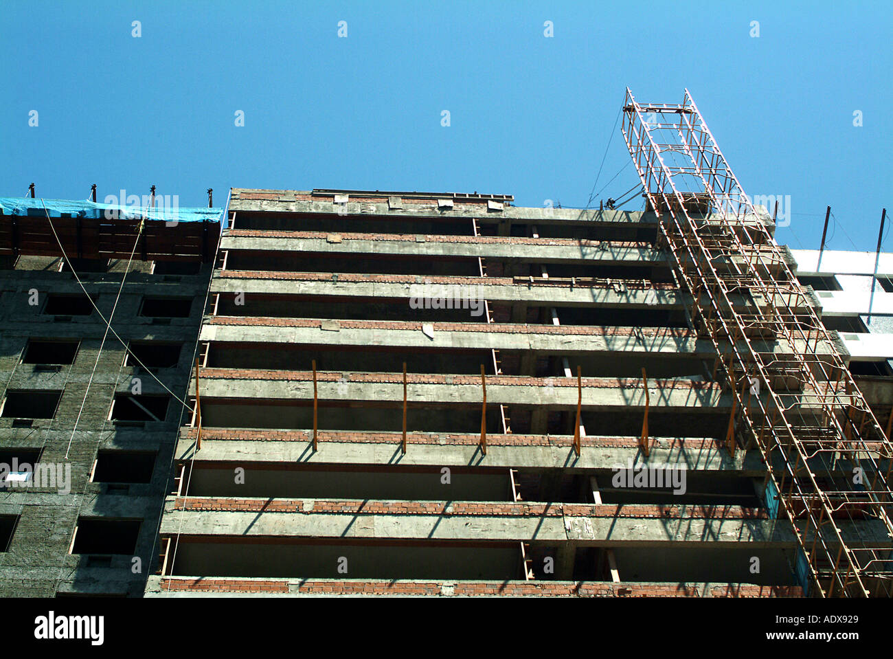 Architecture building tall hight scaffold construction block of flats storeys floors unfinished day daylight sunny cloudless Stock Photo