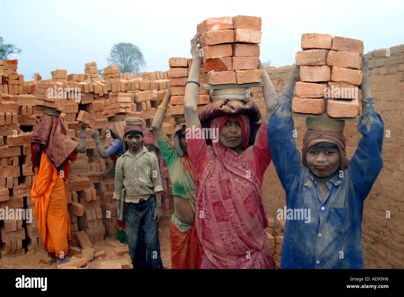 Women and children are doing heavy labour by working in stone factories Stock Photo