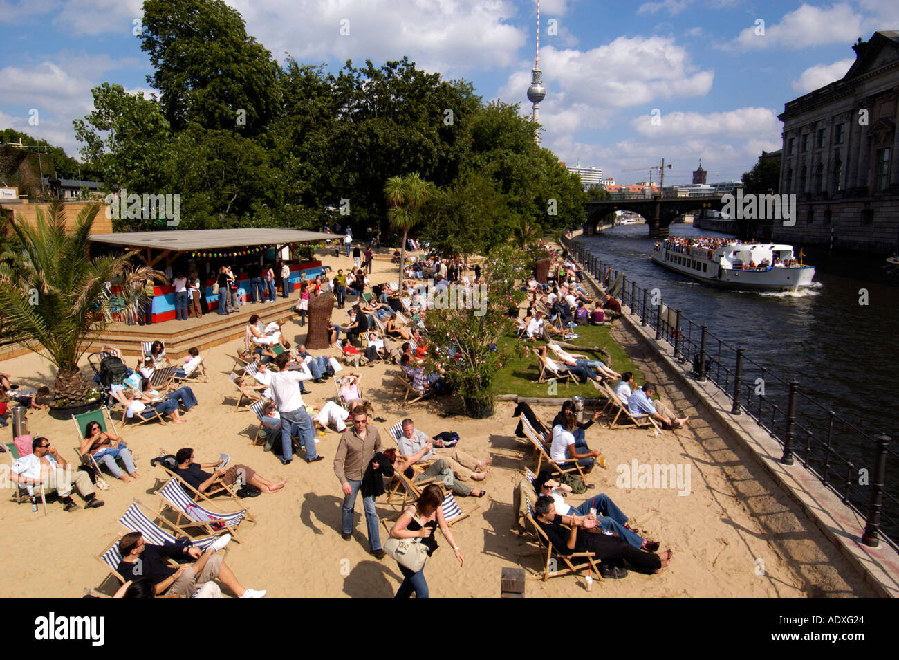 People throng a sandy city beach built in beside the Spree River in central Berlin Stock Photo