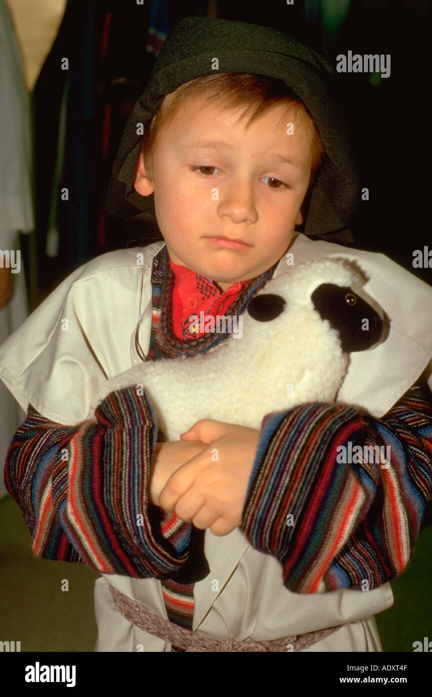 Young shepherd age 7 hugging his lamb at Christmas pageant. Western Springs Illinois USA Stock Photo