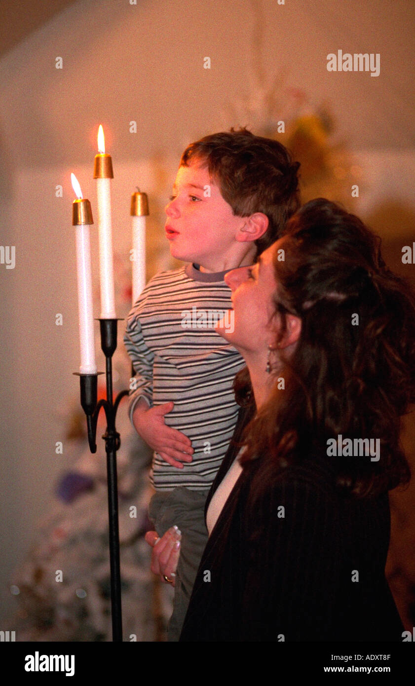 Mother age 32 helping son 4 blow out candles after cousin's baptism