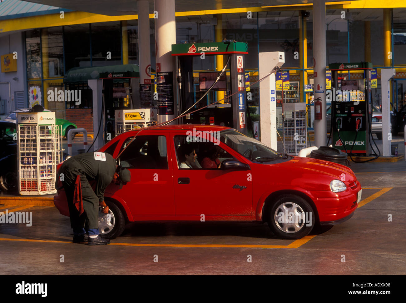 Mexican man, gas station attendant, checking tire pressure, filling gas tank, Pemex gas station, gas station, Mexico City, Federal District, Mexico Stock Photo