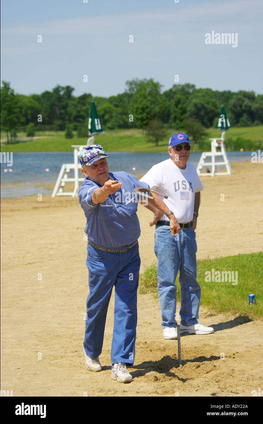 EVENTS Libertyville Illinois Two men play horseshoes on beach Independence Grove lake Stock Photo
