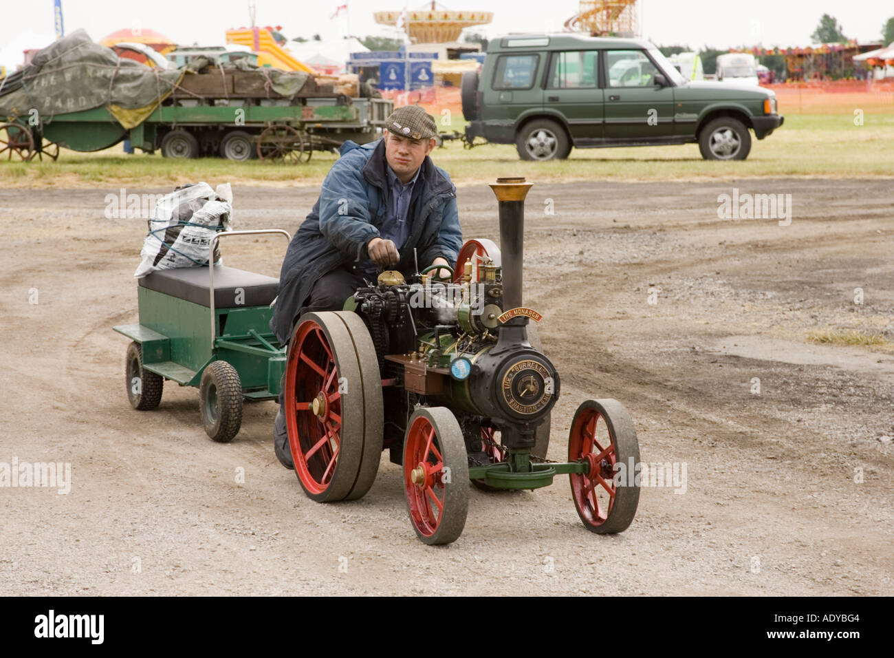 a man driving a scale steam traction engine at Rougham Fair in Suffolk in June 2006 Stock Photo