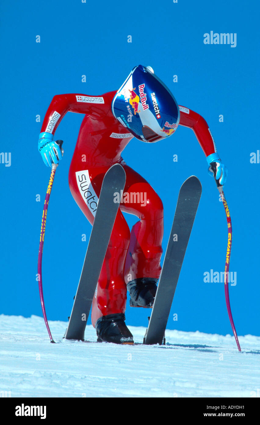 high speed skiing, wearing racing suit and helmet, holding ski ...