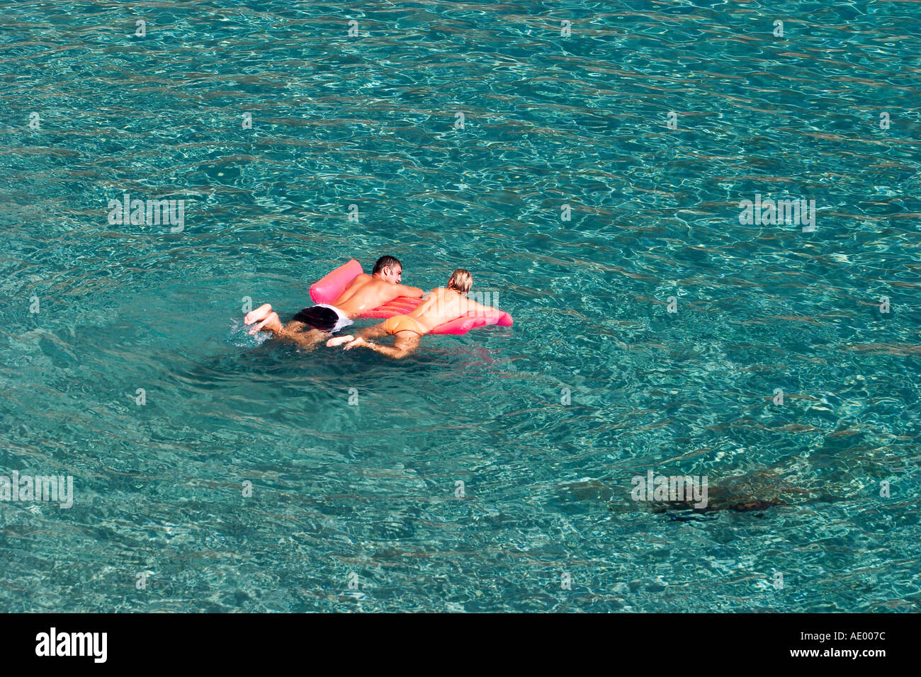 swimmers on airbed in Cala de Boix near Santa Eularia on Ibiza Stock Photo