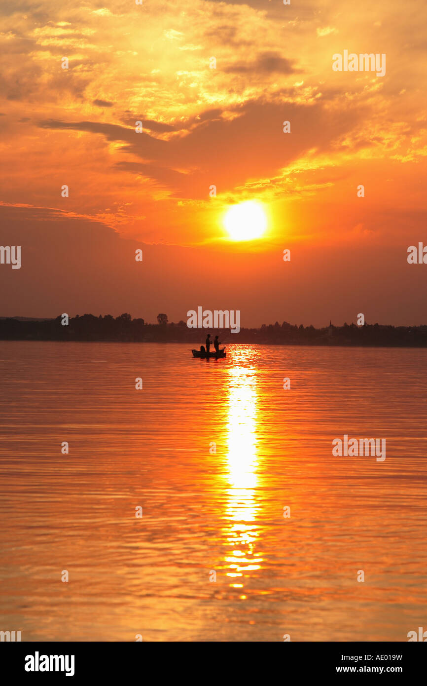 sunset at the lake with boat with anglers, Germany, Bavaria, Chiemsee Stock Photo