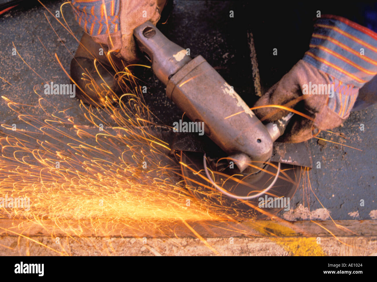 Grinding steel using a pneumatically powered grinder Stock Photo