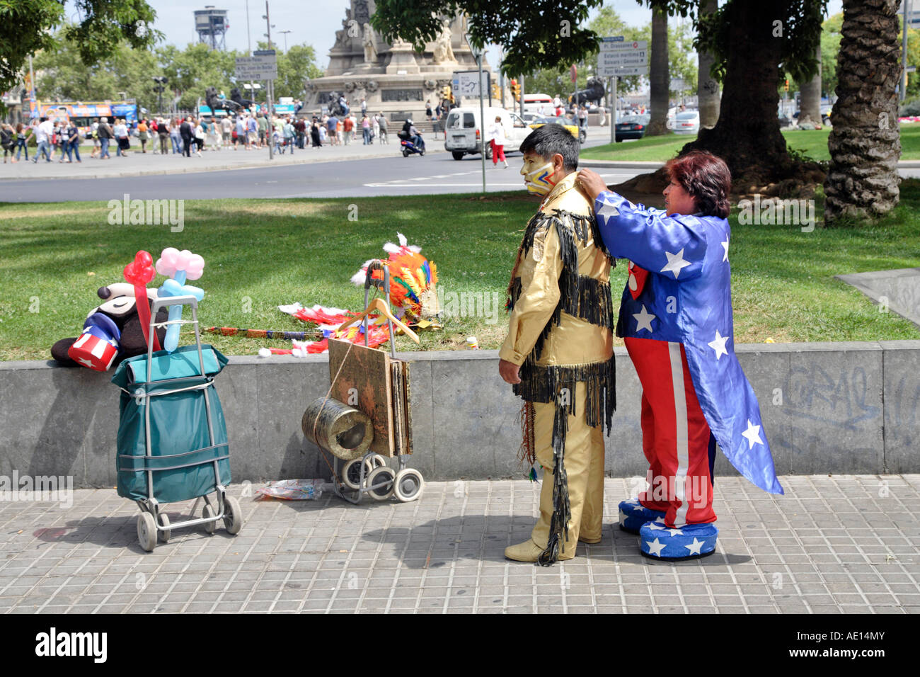 a woman dressed as minnie mouse helps a man into his native american costume in barcelona, spain Stock Photo