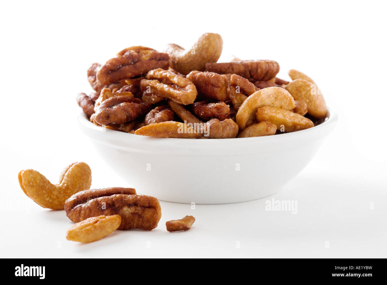 A bowl of mixed nuts with cashews almonds pecans with a white background cutout Stock Photo