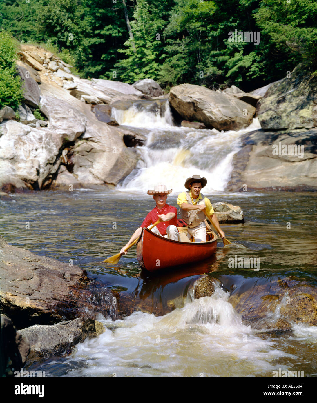father son paddling a canoe in fast moving rapids Stock Photo Alamy