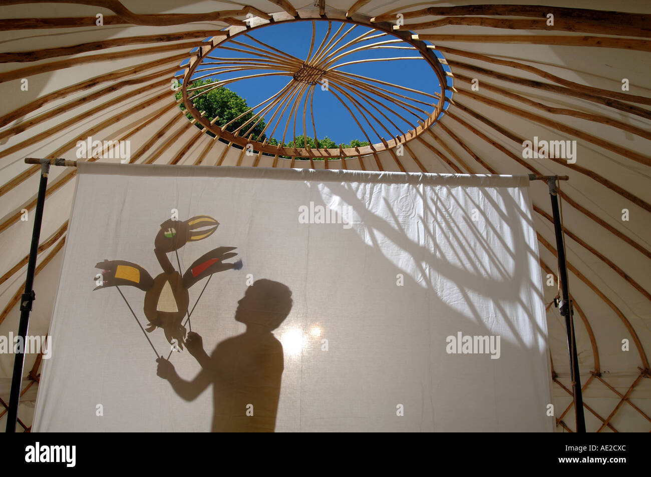 A shadow puppet being played with by a young boy inside a yurt in south ...