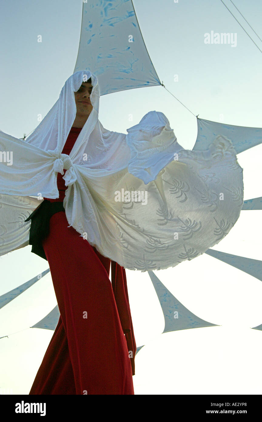 Hilltop 2006 - slender boy with white veil dancing at rave party on stilts Stock Photo