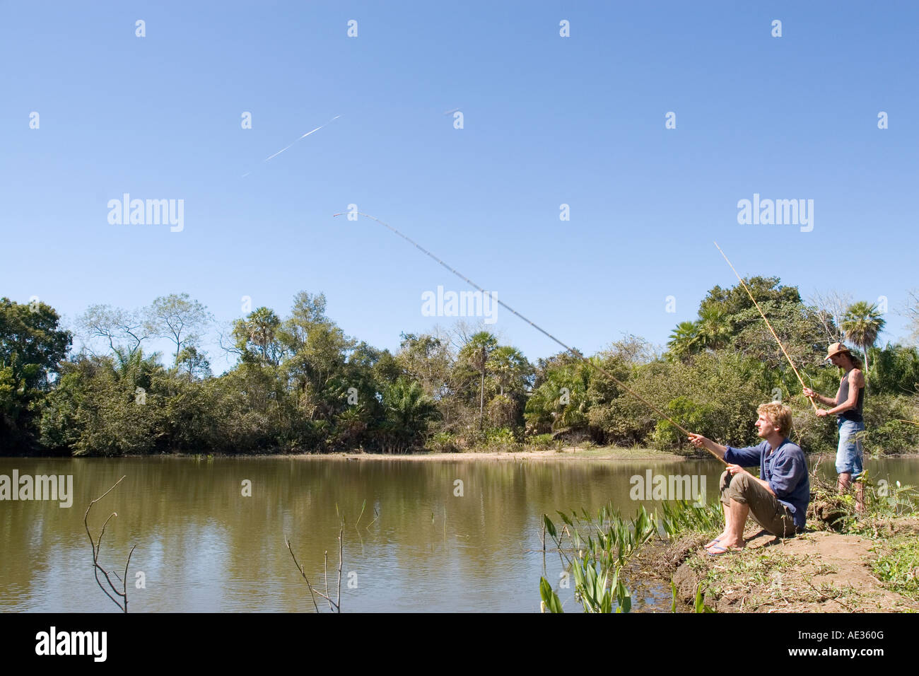 Two Male Figures Fishing in Lake in the Pantanal, Brazil Stock Photo