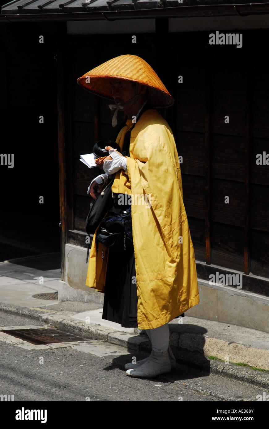 A Buddhist monk quietly begs for alms on a cobbled street below Kiyomizu Temple, Gion, Kyoto Stock Photo