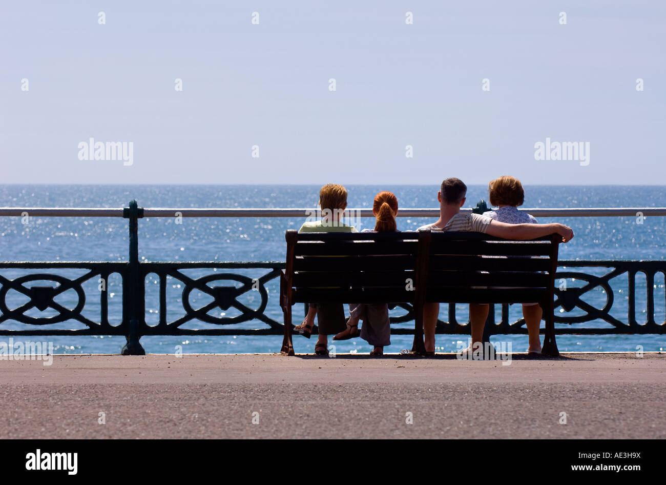 A family sit together on the seafront in Brighton on a warm summer afternoon. Picture by Jim Holden. Stock Photo