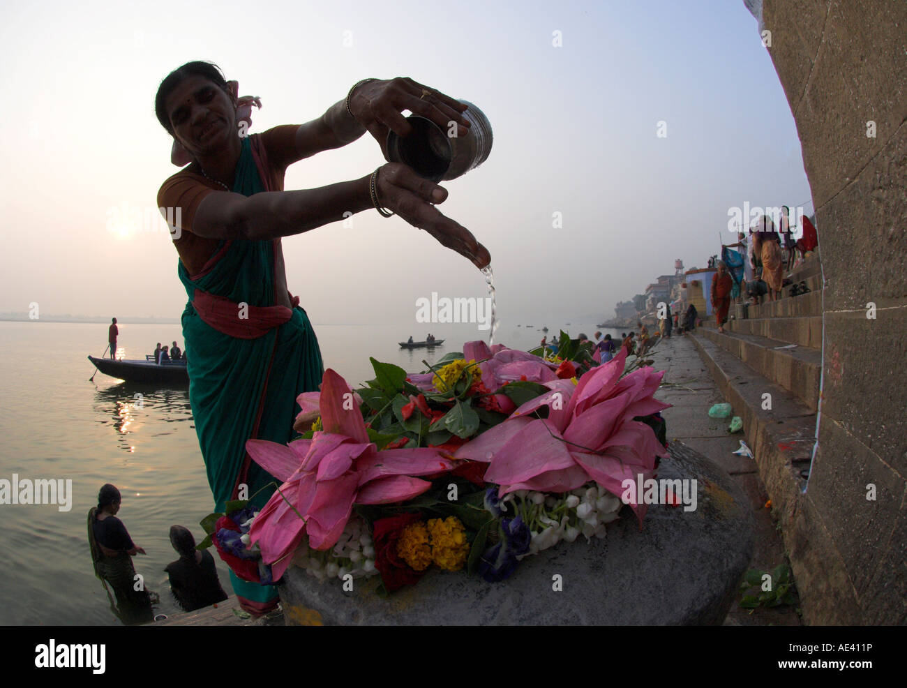 Woman pouring water over flowers on an altar as a religious ritual