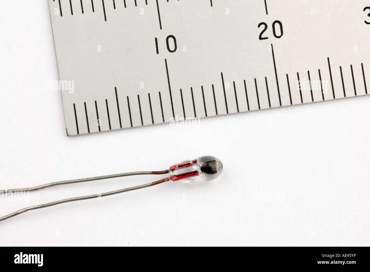 A bead type thermistor next to a ruler to show scale Stock Photo Alamy