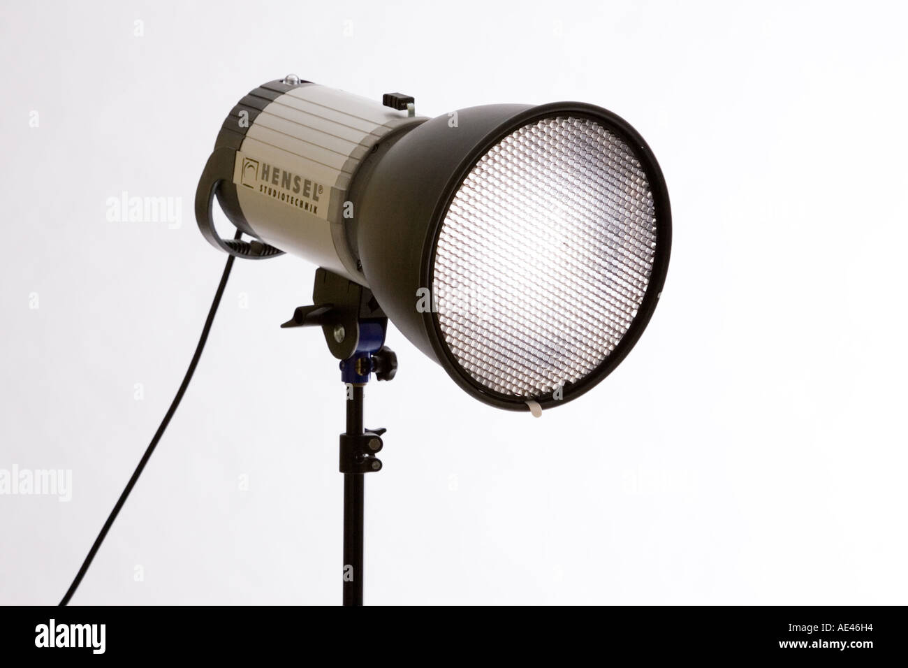 A photographic studio flash lighting head and reflector with grid at front Stock Photo