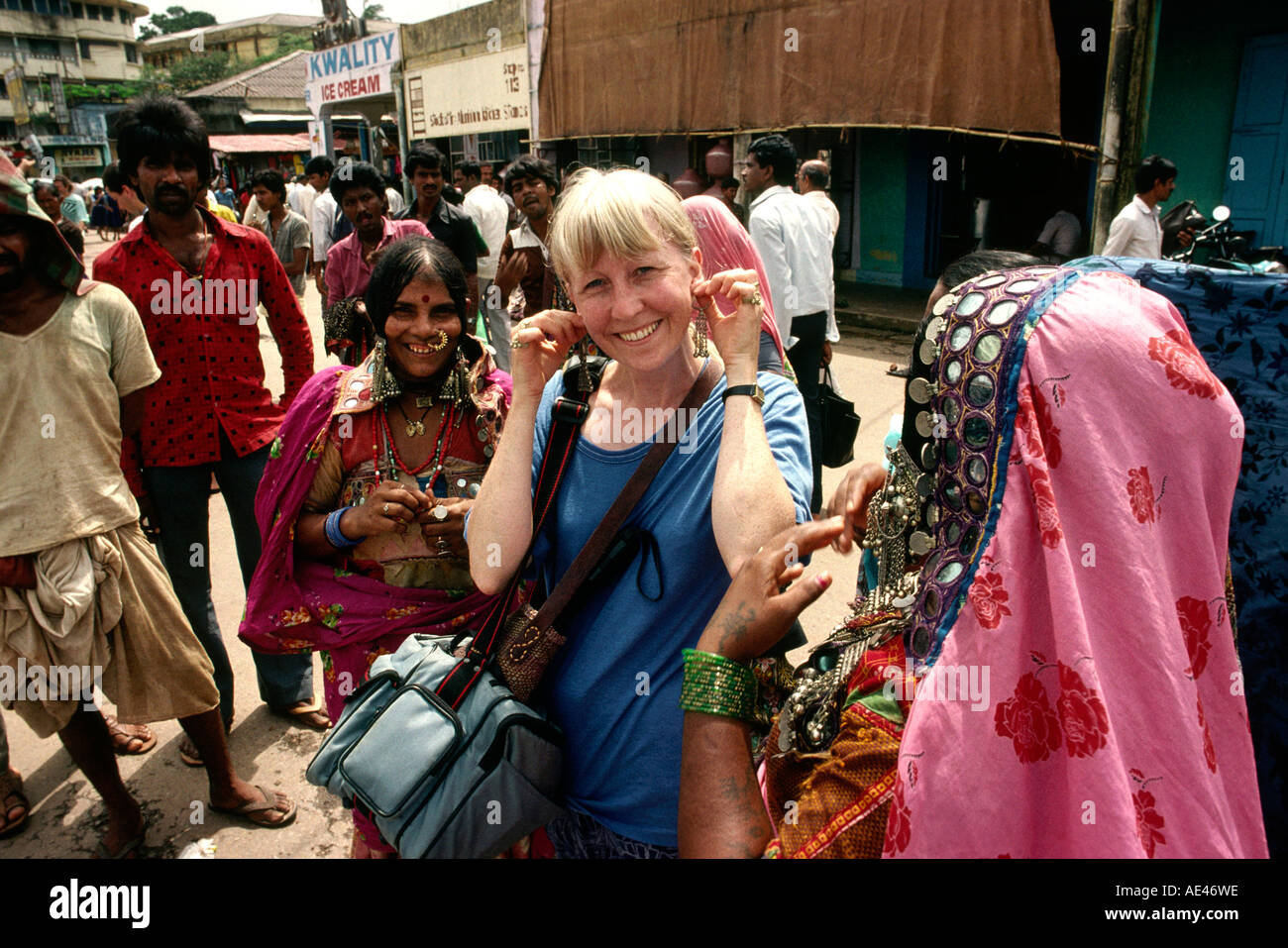 India Goa Mapusa market European woman tourist amongst bejewelled Banjara tribal women Stock Photo