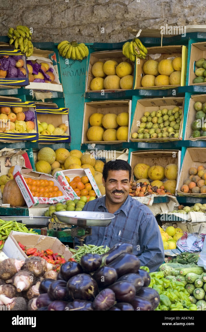 Fruit and vegetables seller at his stall Luxor street market Egypt