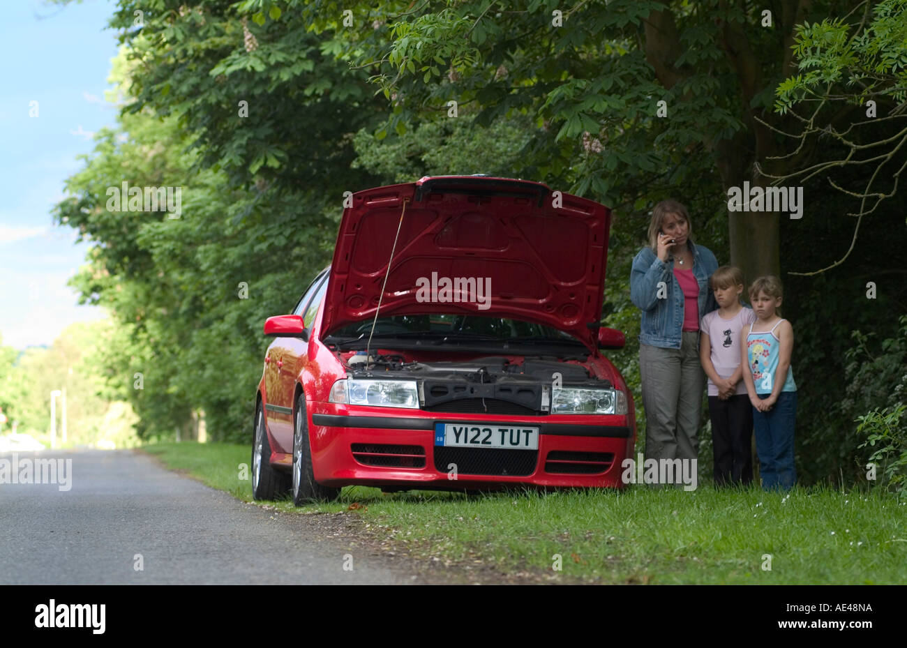 Family at the roadside with car breakdown calling for assistance on a mobile phone. Stock Photo