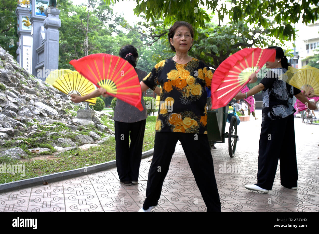 Older women practise fan dance steps entrance to Ngoc Son Temple at