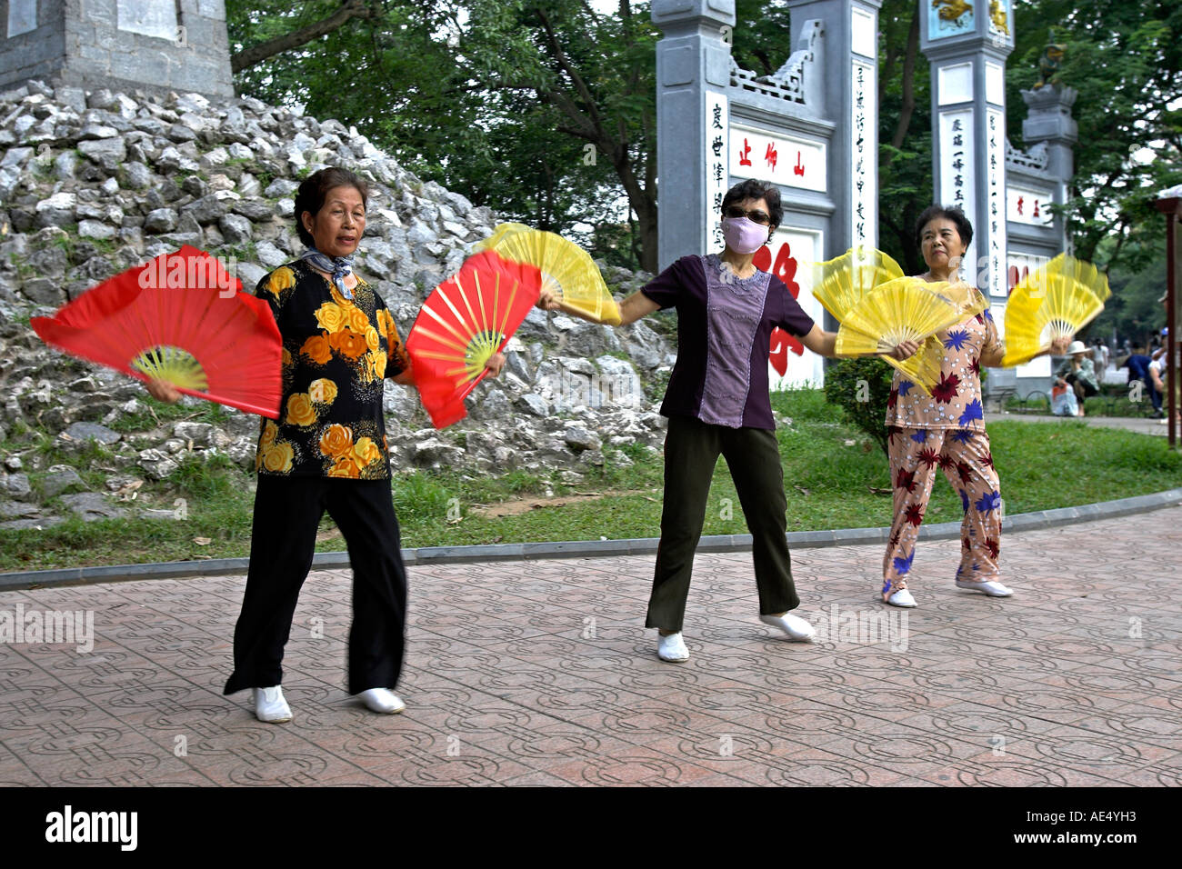Older women practise fan dance steps entrance to Ngoc Son Temple at