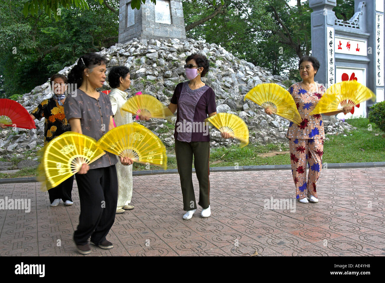 Older women practise fan dance steps entrance to Ngoc Son Temple at