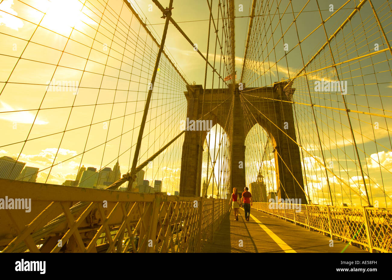 a couple crosses the Brooklyn Bridge going towards Manhattan in the ...