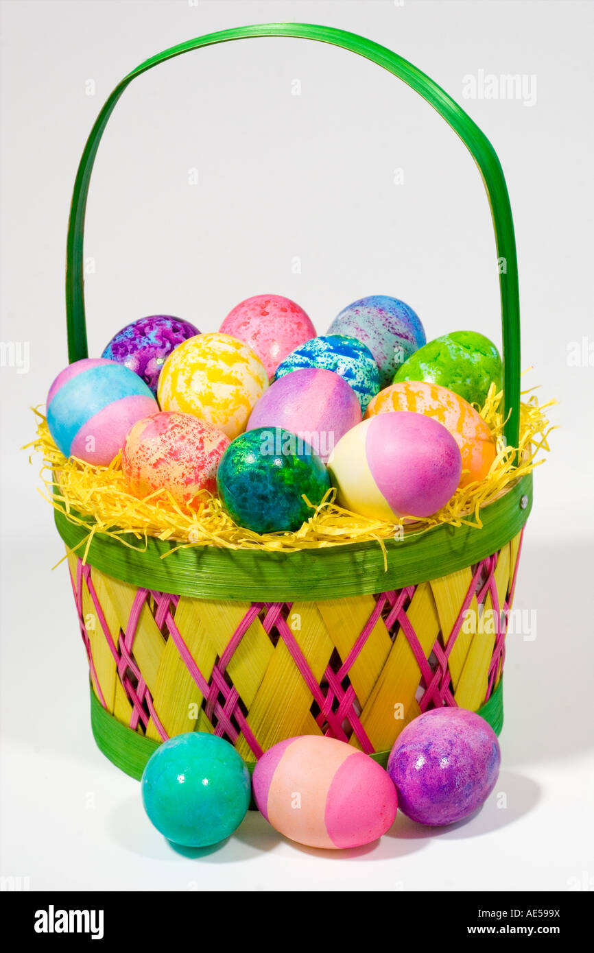Straw Easter basket filled with eggs of different colors and patterns  against a white background Stock Photo - Alamy