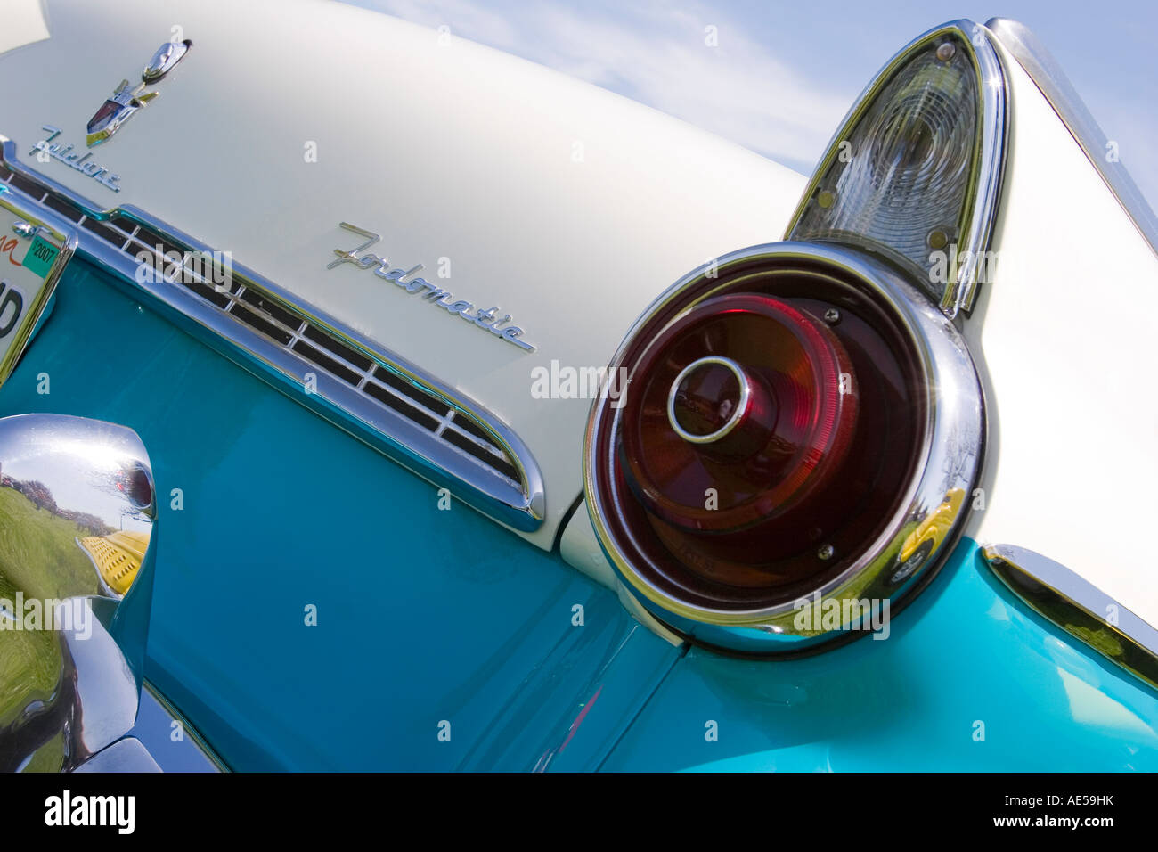 Rear fender fins tail light and emblems on a turquoise and white 1955 Ford Fairlane convertible classic car Stock Photo
