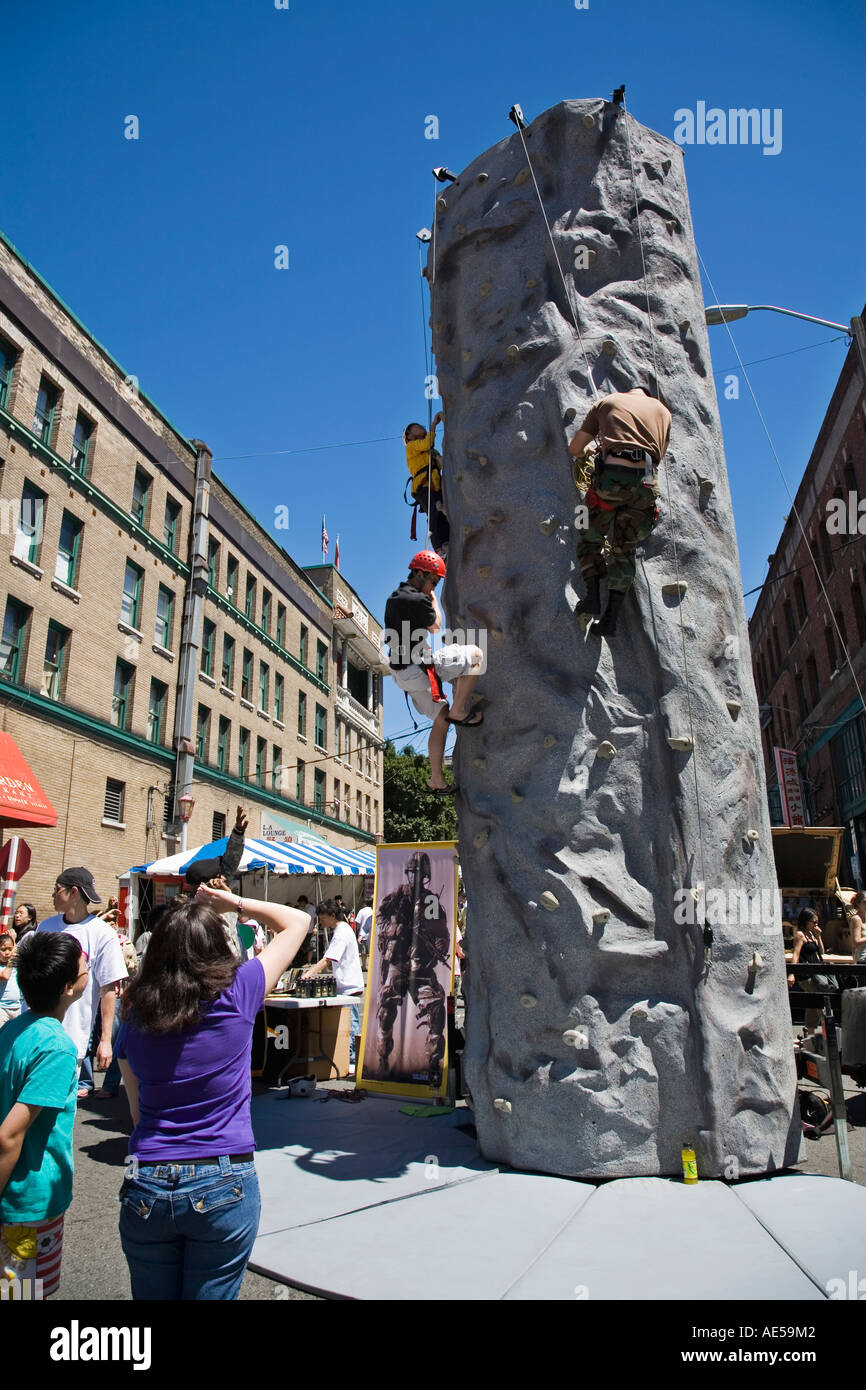 Boys on rock climbing exhibit at US Army recruiting booth at the International District neighborhood street festival Seattle WA Stock Photo