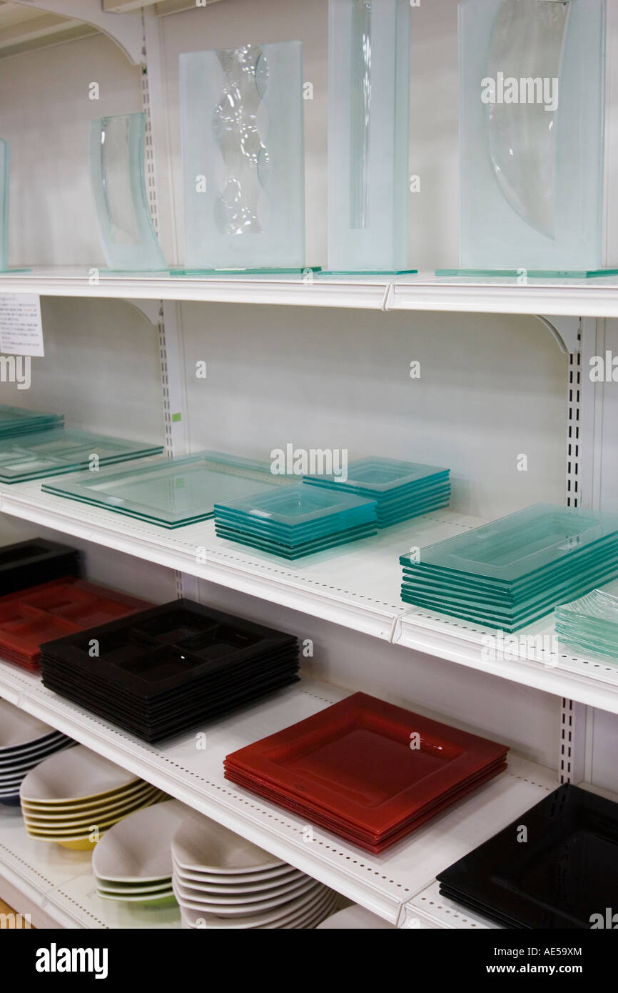 Shelves of modern glass plates vases and serving dishes on the shelves of a Japanese store selling kitchenware Stock Photo
