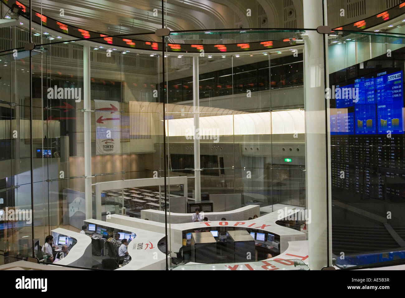 People sitting at trading desk inside glass room at the Tokyo Stock Exchange in Japan Stock Photo