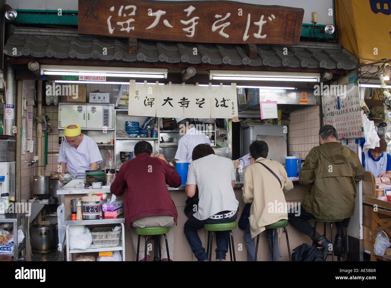 Tiny restaurant stall serving Japanese breakfast food to customers in the outer market of Tsukiji Fish Market in Tokyo Stock Photo