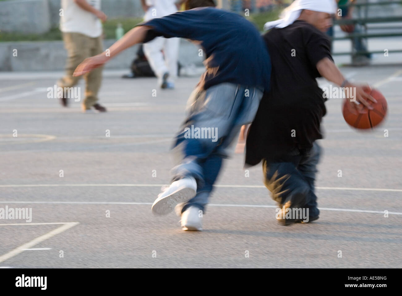 Black and white boys in baggy clothes playing basketball on city courts in  Venice Beach Stock Photo - Alamy