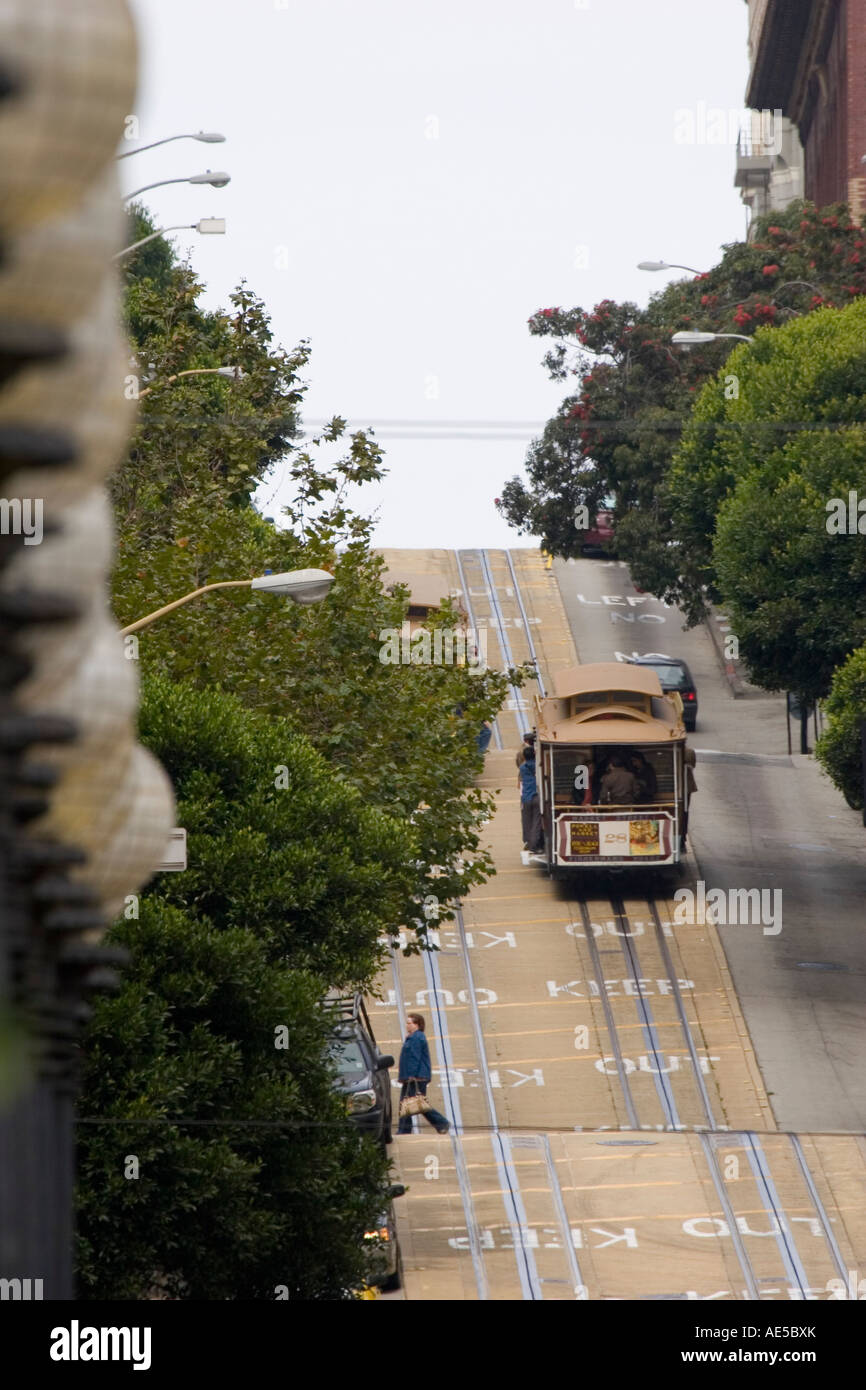 Cable car filled with tourists on vacation making its way up a steep section of Powell Street in San Francisco California Stock Photo