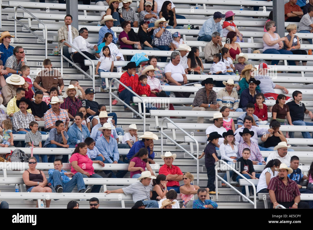 Rodeo crowd with cowboy hats sitting in the stadium bleacher seats at