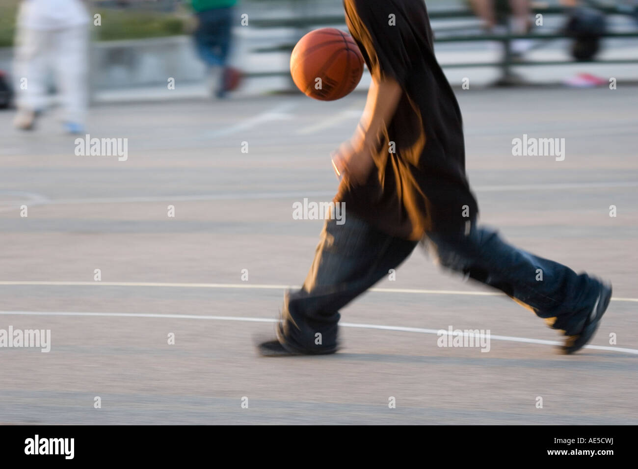 Kid dribbling the ball playing basketball on city courts in Venice Beach California Stock Photo