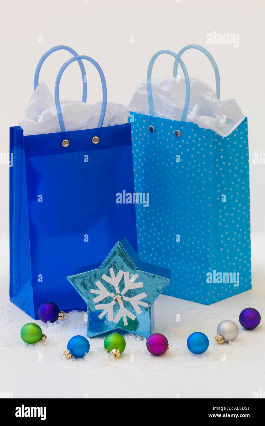 Three blue gift bags with tissue paper and snowflake star shaped box