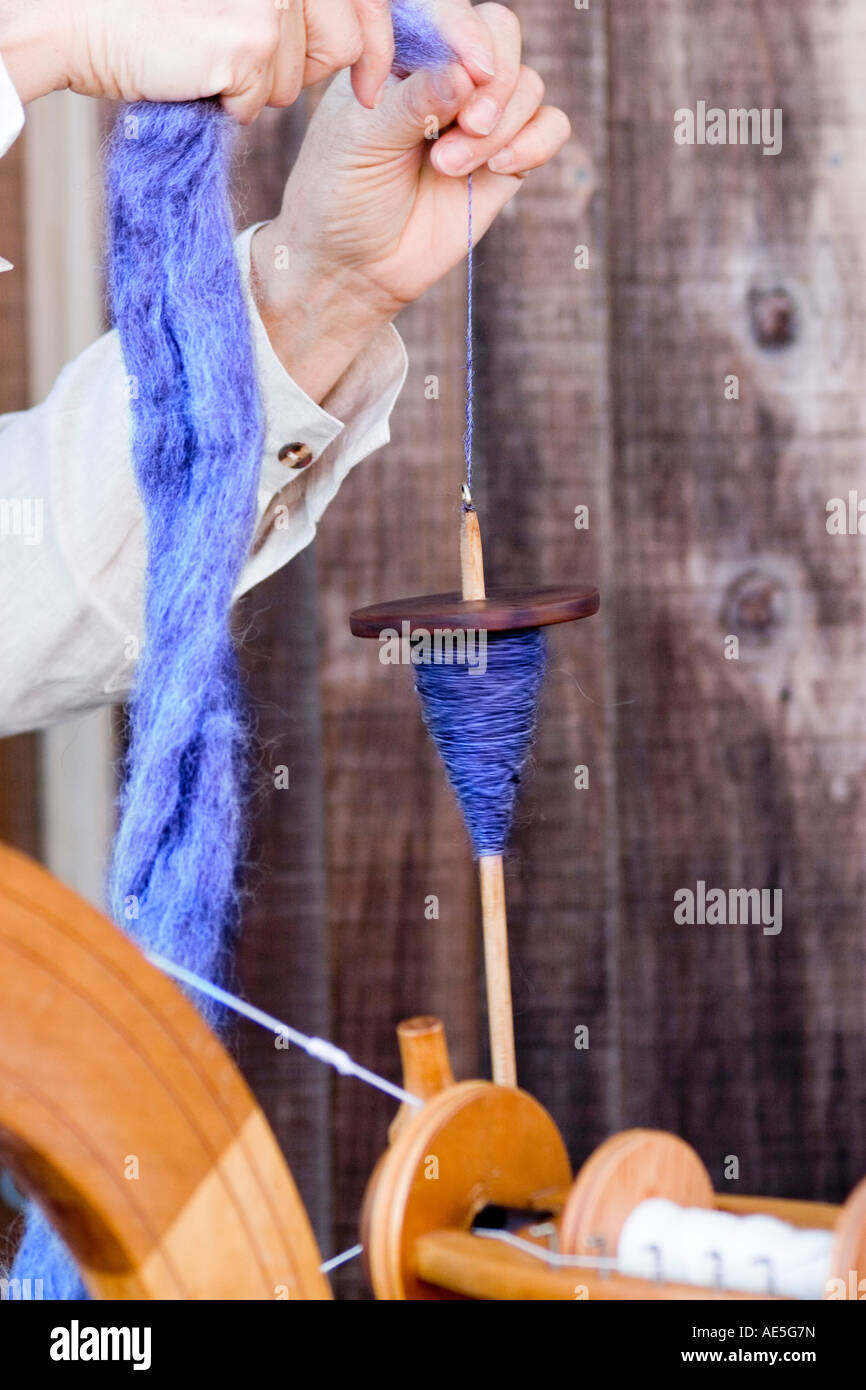 Hands hand spinning wool yarn using old fashioned spindle as