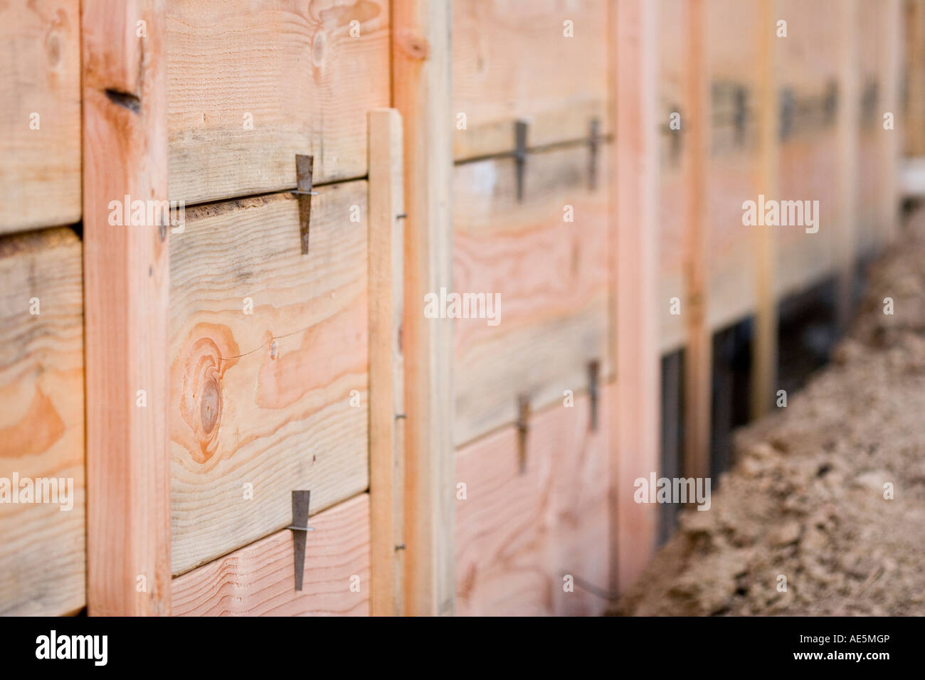 Layers of wood planks made into form wall used to pour reinforced concrete foundation at a