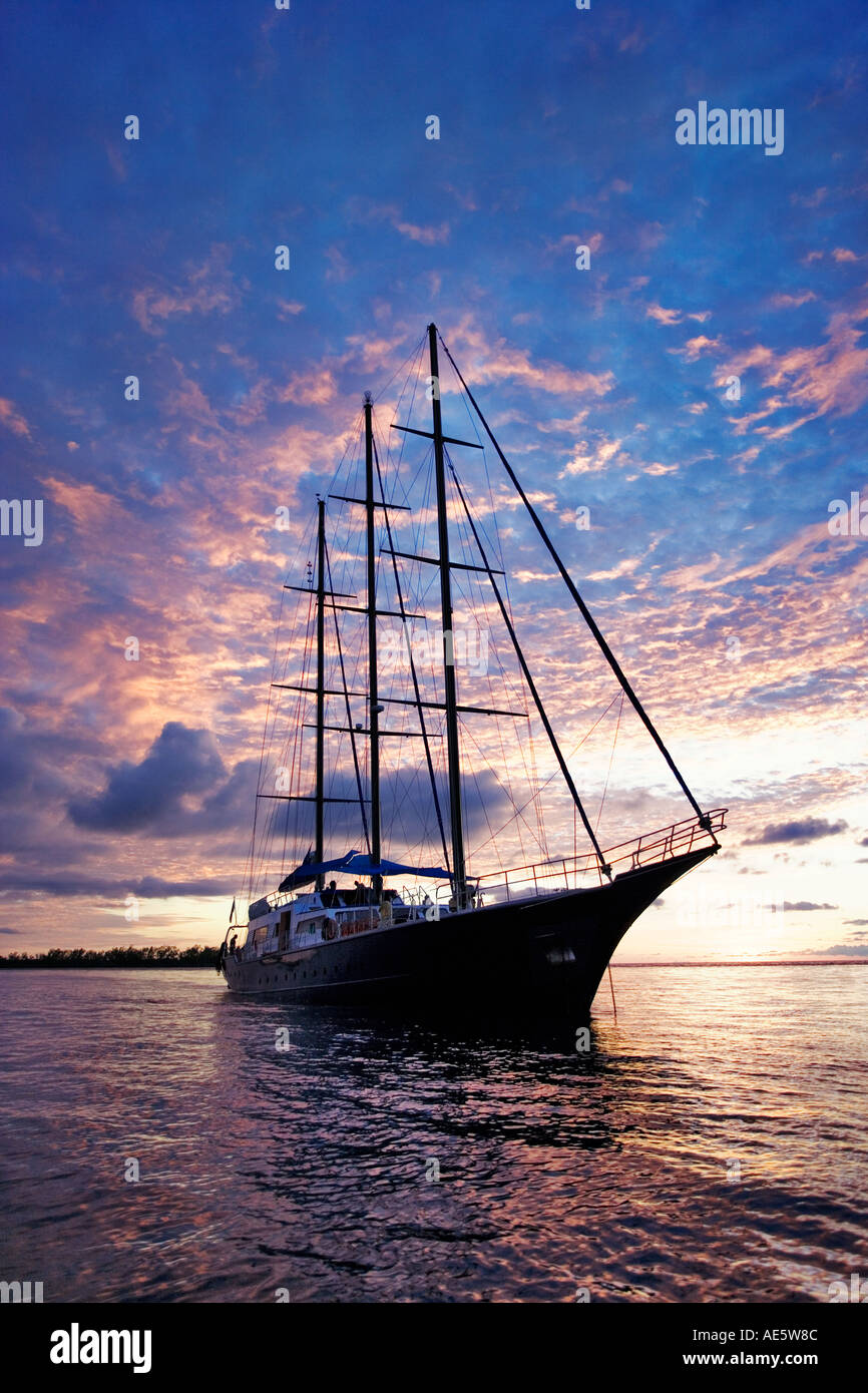 Yacht silhouetted against sunset Sea Star Sailing Yacht Property released Seychelles Stock Photo