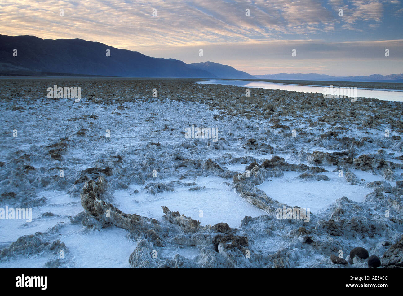 Black Mountains and flooded salt pan at sunrise Devils Golf Course ...