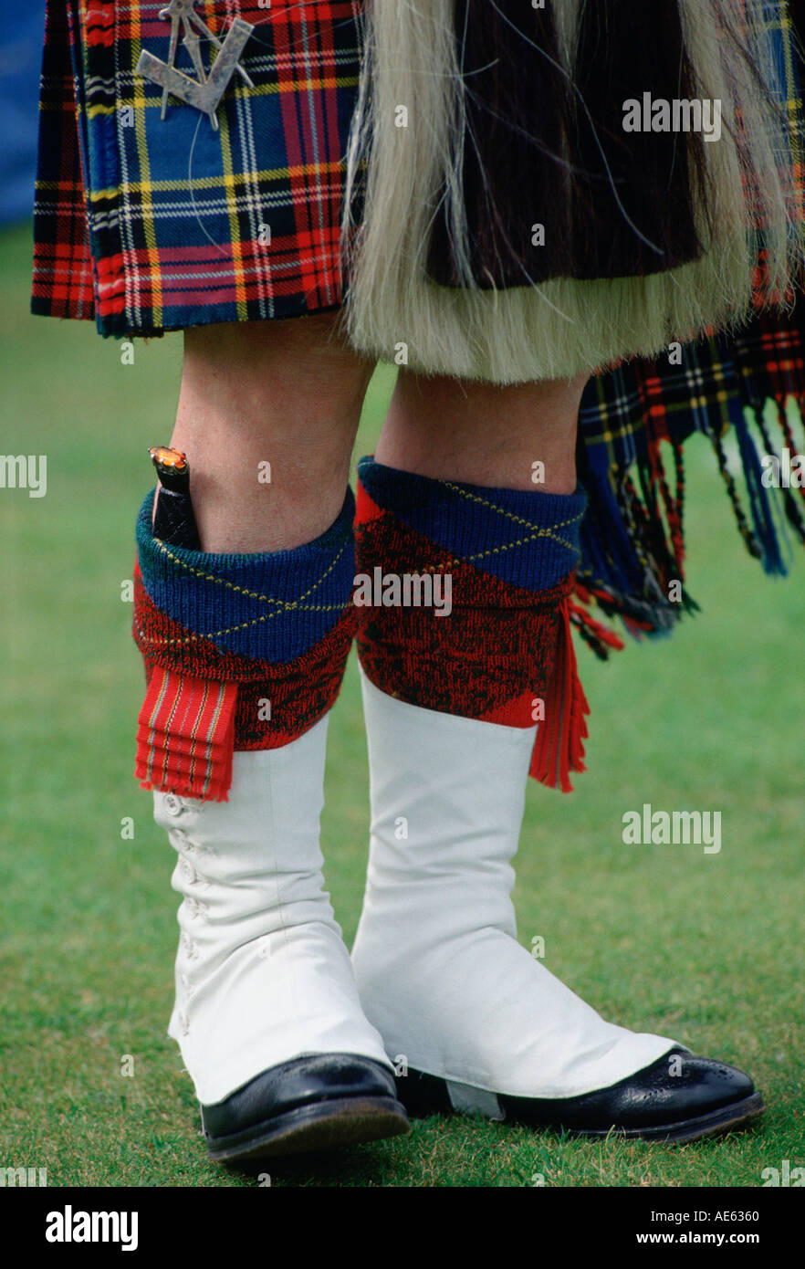 Scottish piper in tartan kilt with dirk knife at Braemar Games Highland gathering Scotland Stock Photo