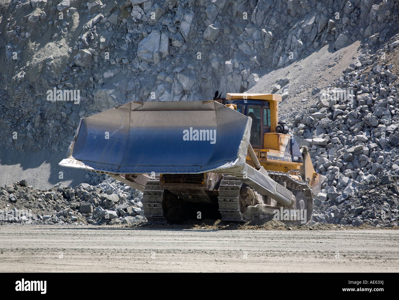 A giant D9 CATERPILLAR TRACTOR moves ROCK at the GRANITEROCK QUARRY