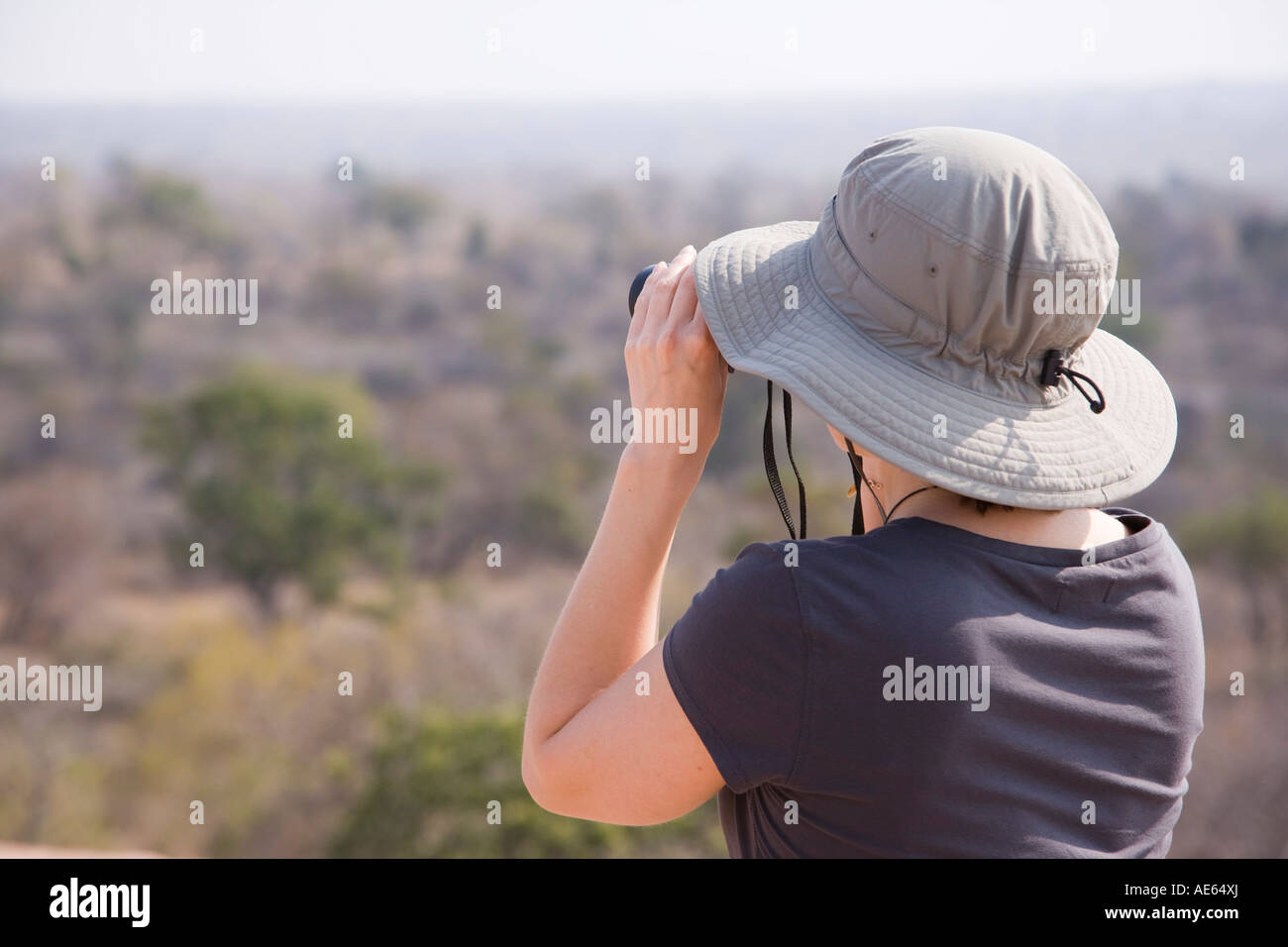 A young woman surveys the landscape of Kruger National Park through her