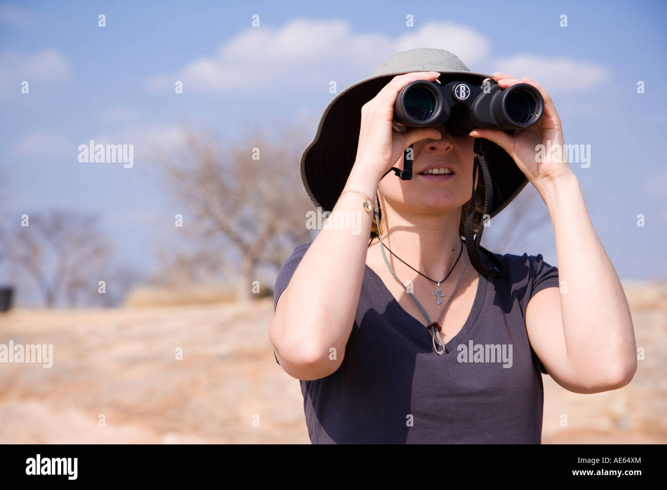 A young woman surveys the landscape of Kruger National Park through her